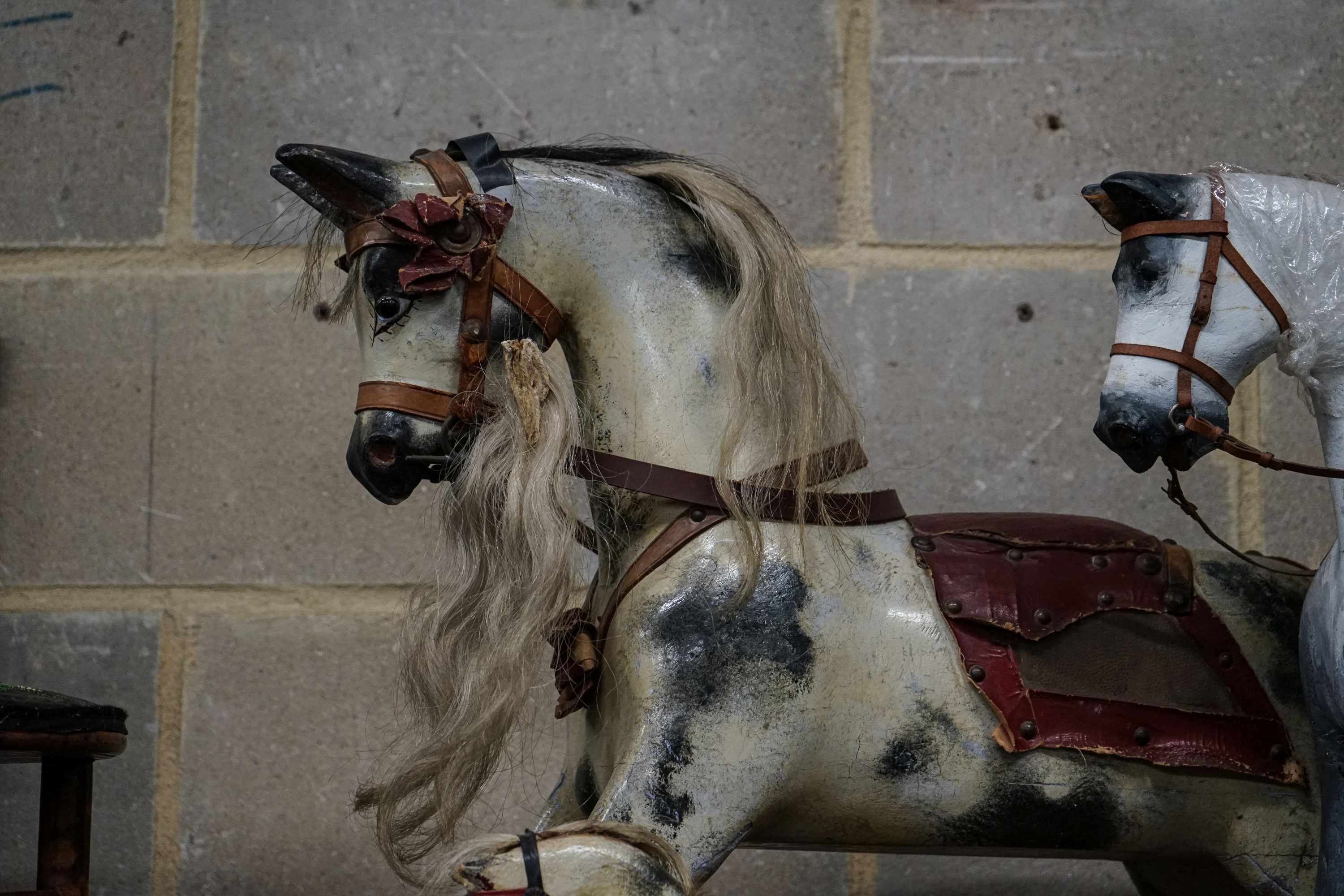 A Victorian carved and painted wood rocking horse, lacking underframe, length 77cm and two painted wood hobby horses, 58cm and 38cm